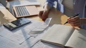 Woman hands calculating finances expenditures checking notes in notebook closeup. Unknown accountant using calculator checking bills taxes at home workplace. Lady manage plan household budget at desk. - Powered by Shutterstock - Get 15% off with code: PIKWIZARD15