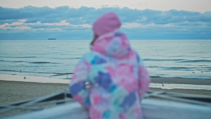 Caucasian Girl in Warm Jacket Looking at Calm Sea Waves and Horizon