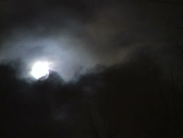 Full Moon and clouds over stormy night skyline.