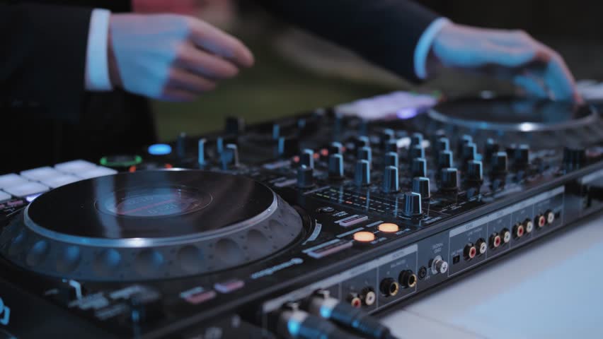 Close-up of Wedding DJ man play and adjust controller with vinyl on the wedding, event.
