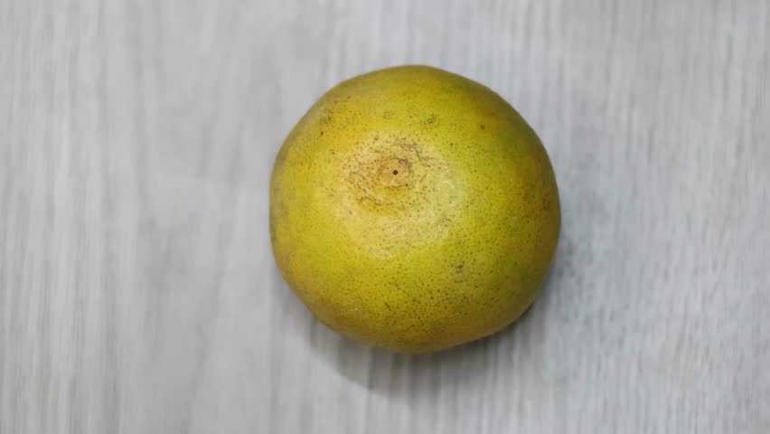 Close-up sequence of hands peeling an orange, revealing the juicy segments beneath the rind.