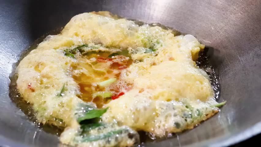 Cooking an omelet in a wok