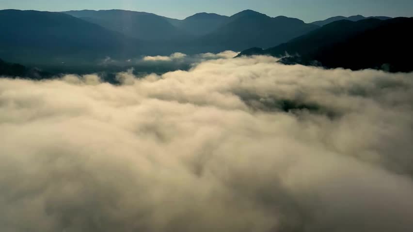 Aerial View of Rolling Fog Over Mountain Range at Dawn