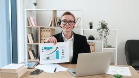 Potrtait of businesswoman in thirties presenting financial graphs during online meeting using laptop, showcasing growth data. - Powered by Shutterstock - Get 15% off with code: PIKWIZARD15