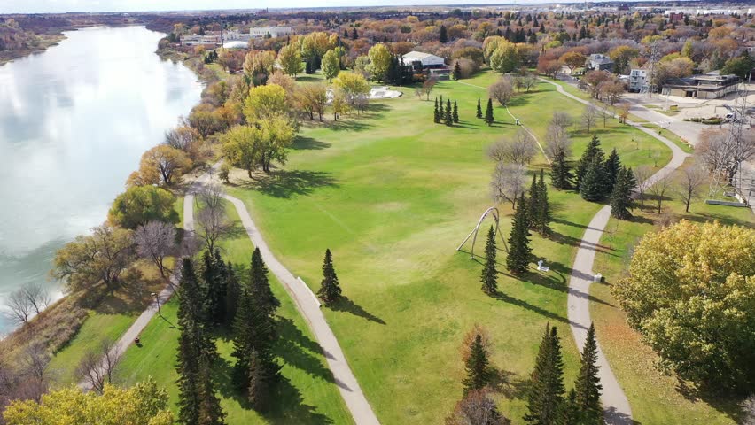 Golf course with a river in the background. The golf course is surrounded by trees and has a path leading to it