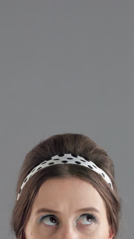 Closeup, eyes and woman in studio, thinking and decision with questions on gray background. Person, mockup space and model with ideas, curious and brainstorming with makeup, confused and solution