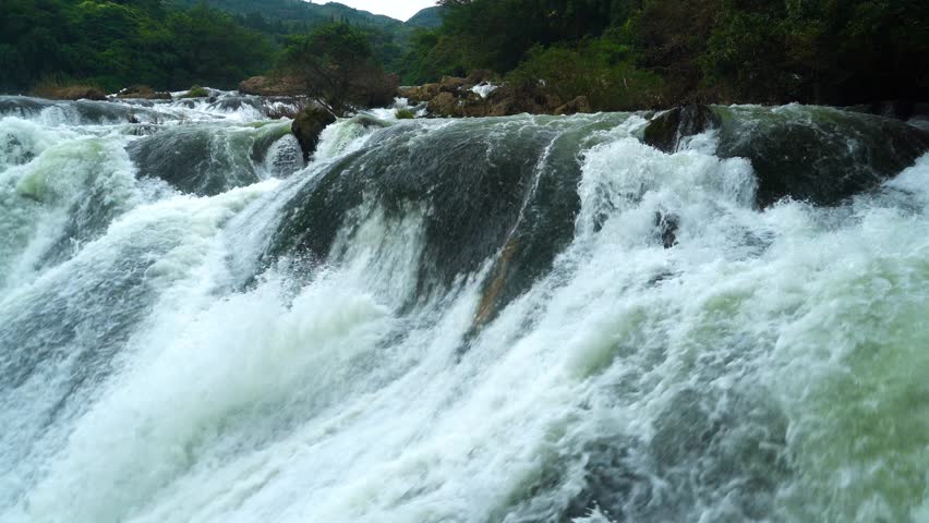 Exploring natural beauty with silver chain waterfall flowing into serene pool