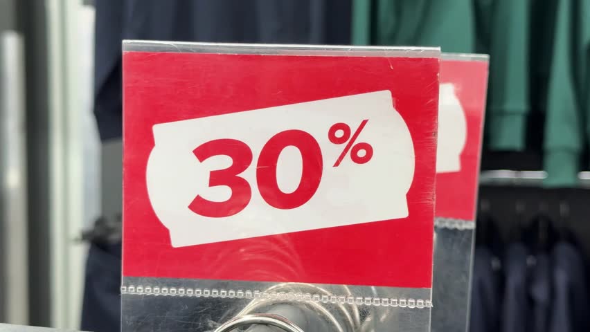Red discount sign showing 30 percent off in a clothing store