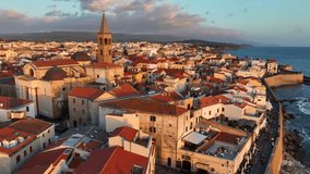 establishing drone shot of Alghero port and old town in Sardinia, vacations in Sardinia, Italy, aerial view of coastal ancient town in Sardegna, sunset in Alghero. High quality 4k footage - Powered by Shutterstock - Get 15% off with code: PIKWIZARD15