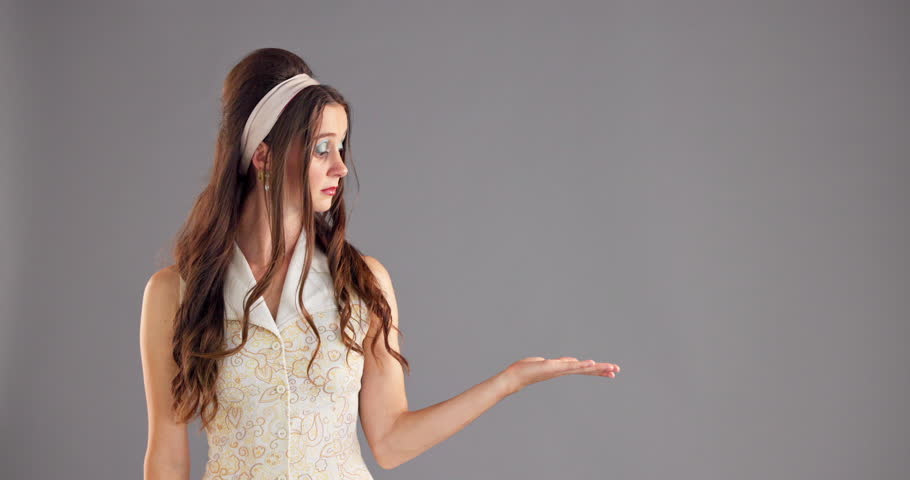 Woman, face and question with hand for promo, advertising or marketing on grey studio background. Portrait, female person and vintage fashion for selection, choice and retro opinion on mockup space