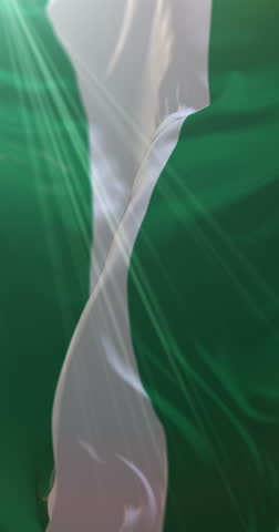 Flag of Nigeria waving at wind in slow in blue sky, loop. 4K Vertical