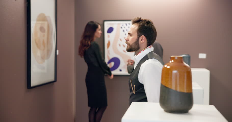 Man, painting and exhibition at art gallery with decision for shopping, lines or color in frame. Person, customer and choice for creativity, inspection or sale for product, talent or display at event