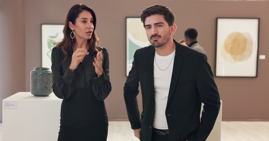 Woman, man and exhibition with talk at art gallery for negotiation, explain and face for deal. People, presentation and customer with shopping, guide and display with culture, talent or pov at event