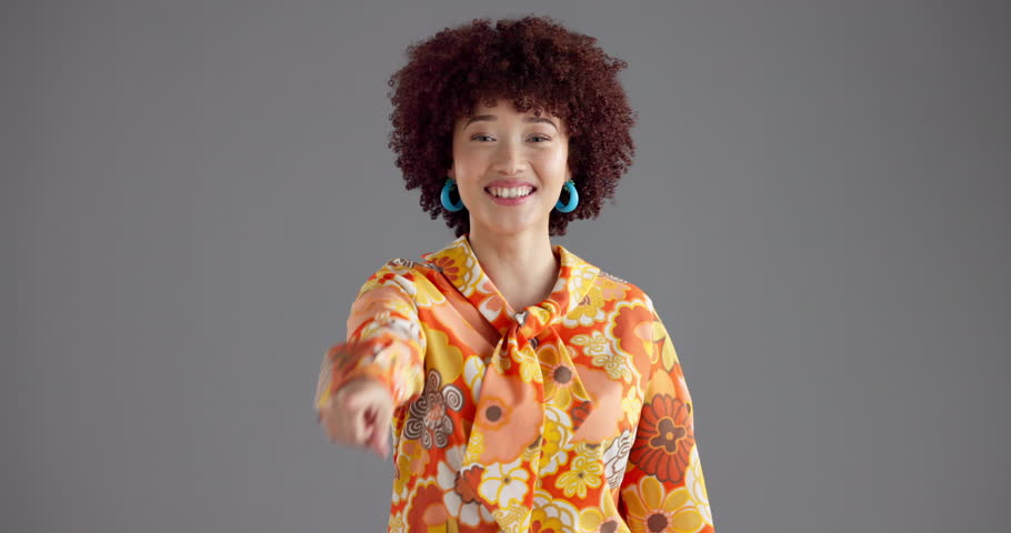Happy woman, face and pointing to you in studio with fashion for selection on a gray background. Portrait, female person or model with afro, retro or vintage style for choice or pick on mockup space