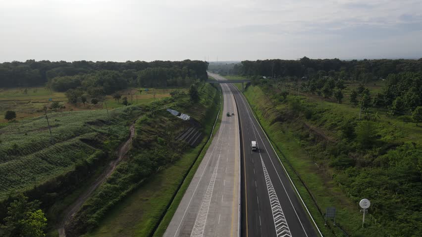 Aerial view of toll road that surrounded by nature in Java, Indonesia.