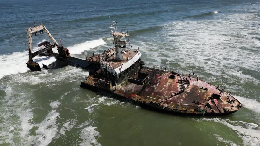 A drone view of Zeila Shipwreck Namibia washed by waves on the South Atlantic Ocean in sunny weather in Skeleton Coast, Jakkalsputz, Namibia