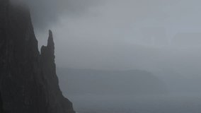 A beautiful shot of Trollkonufingur (Trøllkonufingur) on a dark, gloomy day. The Troll Woman's Finger, Vagar, Faroe Islands. - Powered by Shutterstock - Get 15% off with code: PIKWIZARD15