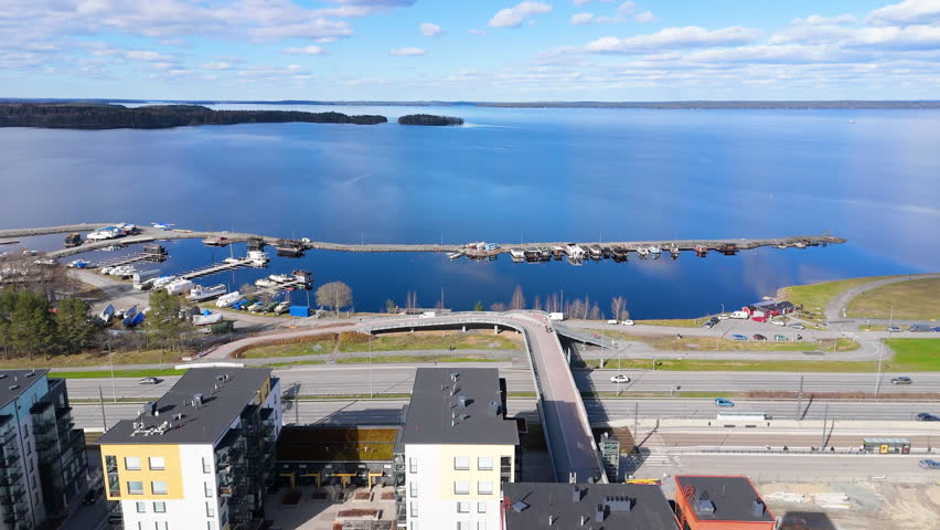 Marina and pier filled with boats. Summer day with traffic and scenic lake. Santalahti Marina in Tampere Finland and Lentävänniemi region in the background. 4K prores footage. Näsijärvi lake.