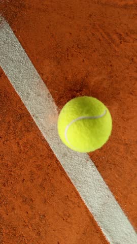 Super Slow Motion Detail Shot of Tennis Ball Hitting a Clay Court . Filmed on High Speed Cinematic Camera at 1000 fps