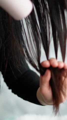 Brunette girl dries long hair with dryer haircare beauty routine concept