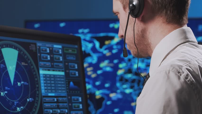 Professional air traffic controller in the control tower. Aircraft control officer works using radar, computer navigation and digital maps. Close-up portrait.