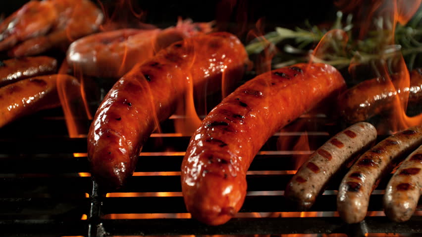 Super Slow Motion Shot of Grilling Tasty Sausages on Hot Grill with Flames at 1000 fps.