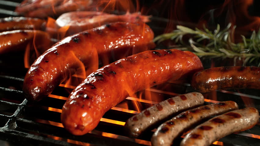 Super Slow Motion Shot of Grilling Tasty Sausages on Hot Grill with Flames at 1000 fps.