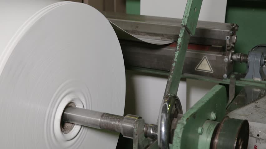 Industrial packaging machine. Automatic polyethylene plastic bag production machine with lighting effect. Close-up of the roller of the plastic bag production machine. Product packaging concept