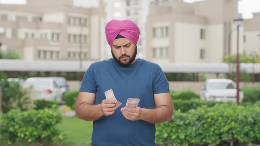 Confussed Sikh Indian Man Counting Money