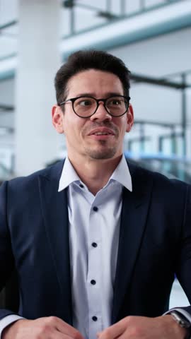 Smiling Hispanic Salesman Successfully Handing Over Keys To New Car Owners At Local Dealership During Business Hours.
