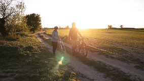 Romantic couple enjoying leisurely bicycle walk on peaceful country road during sunset, embracing nature's tranquility and golden light's warmth - Powered by Shutterstock - Get 15% off with code: PIKWIZARD15