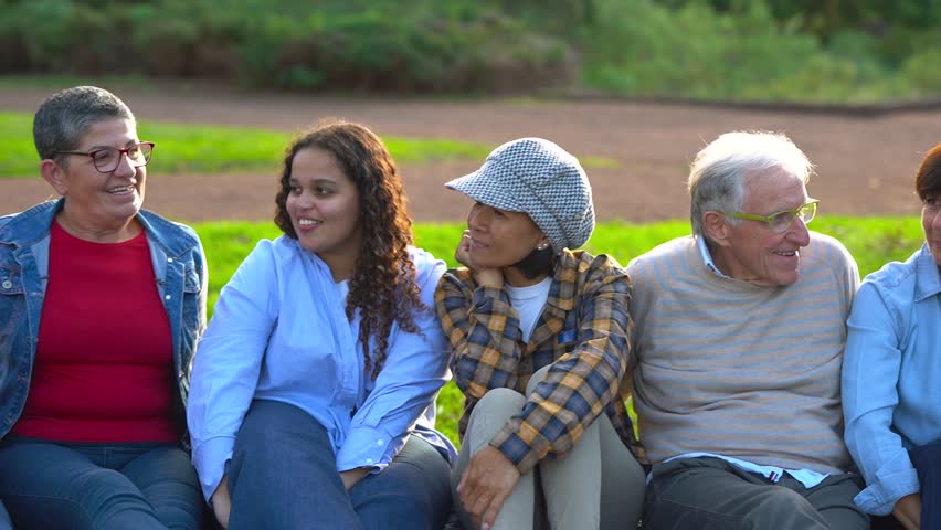 Group of happy multiracial people having fun together at city park - Social gathering and multi generational community concept