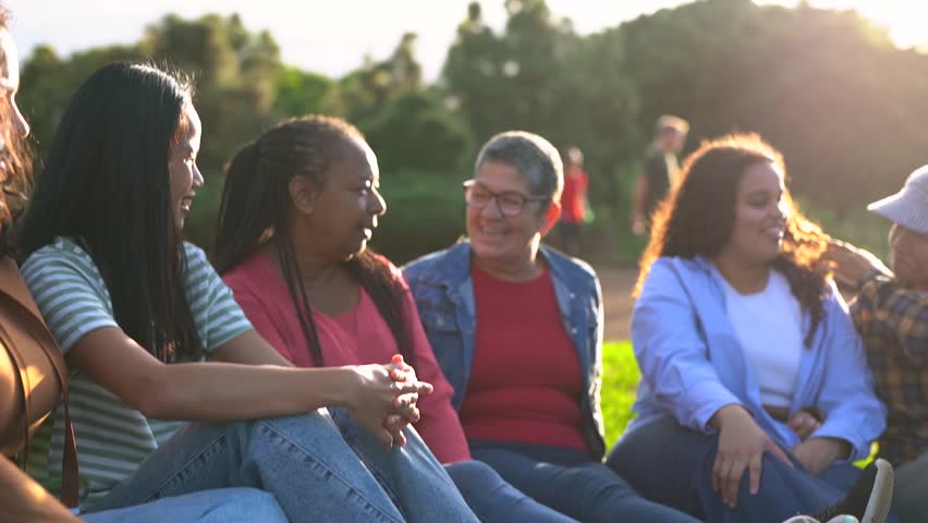 Group of multiracial people having fun together at city park - Multi generational community and social gathering concept