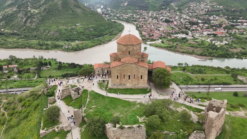 Explore the stunning scenery of an ancient fortress and church in Tbilisi, Georgia, situated amidst lush green landscapes.