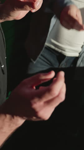 Close-up of two men rhythmically snapping fingers in a recording studio, focusing on their hands and casual attire. creative atmosphere, with studio equipment and green LED lights in the background