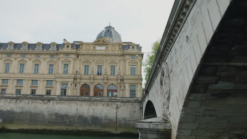 Riverboat cruise on the Seine. A boat sails under the Pont au Change bridge over the Seine River, Paris, France. The bridge is located at the border between the first and fourth arrondissements.