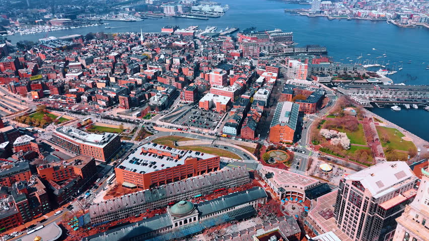 Highly-inhabited waterfront of the river with docks. Boston scenery on sunny daytime. Massachusetts, USA. Aerial view.