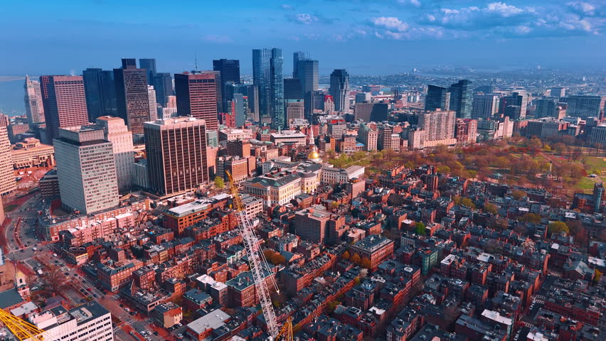 Approaching Boston downtown built with skyscrapers. Drone footage over the old brick buildings of the city.
