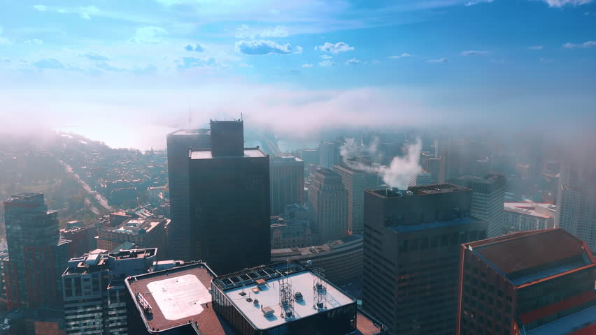Smoke from the pipes rises into the air and spreads over the vast cityscape. Pollution of atmosphere. Aerial view.