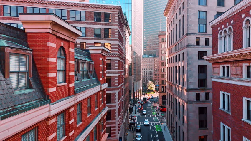 Flight along the streets of modern Boston, Massachusetts, USA. People and cars move by the roads. Aerial view.