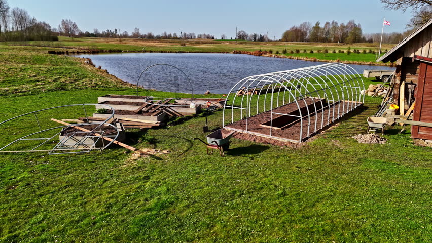 Aerial: farm with a small pond in a rural zone during the day, outdoor, orbit drone shot