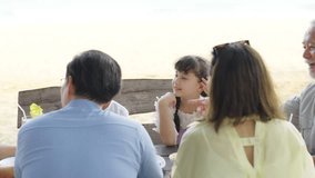 4K Happy Asian Multi-Generation family having lunch eating food together at beach restaurant. Waiter and waitress serving seafood to customer. Family travel nature the sea on summer holiday vacation. - Powered by Shutterstock - Get 15% off with code: PIKWIZARD15