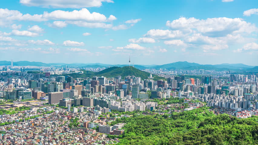 Time lapse video - Seoul city skyline and Seoul tower modern building and architecture, Beautiful clouds flow through in Seoul, South Korea.Zoom in