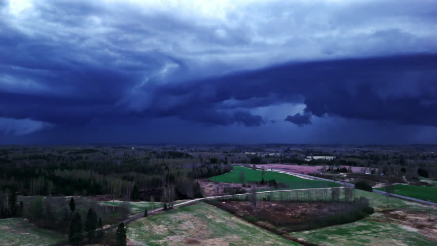Shelf cloud formation over rural landscape with lightning and brewing storm