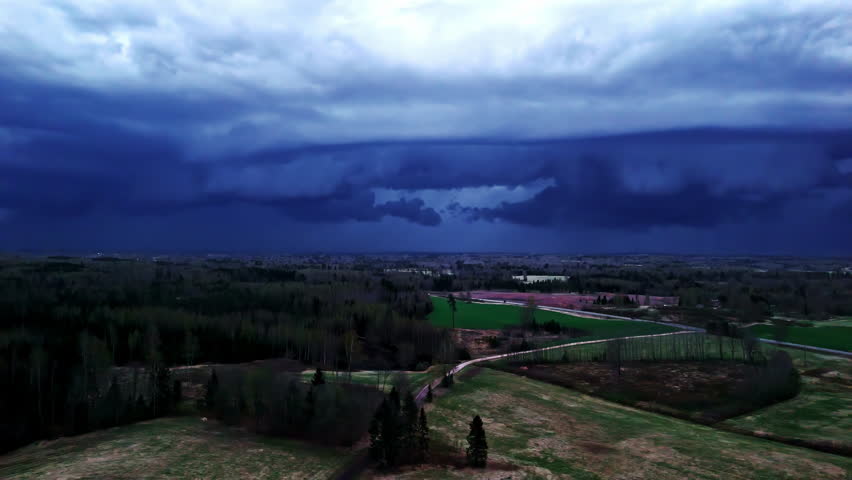 Shelf cloud and lightning over rural landscape during thunderstorm