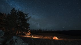 Night camping in mountains. Orange tent and campfire under moving Milky way - Powered by Shutterstock - Get 15% off with code: PIKWIZARD15