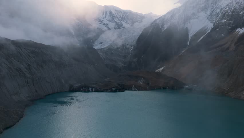 Mountain lake reflection. a view of a clear lake under the foot of a snowy mountain surrounded by mountains. Beautiful Mountain Lake in Nepal. A snowy mountain with Glacial Lake