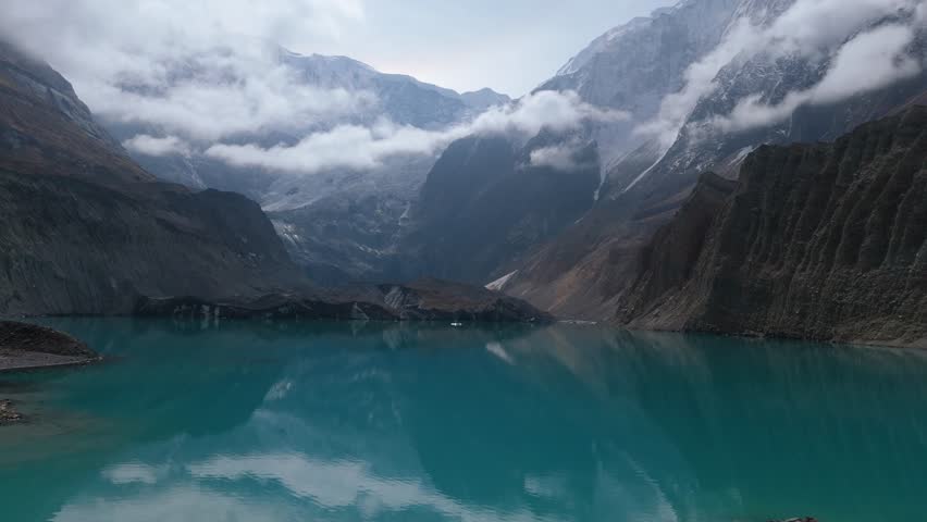 Mountain lake reflection. a view of a clear lake under the foot of a snowy mountain surrounded by mountains. Beautiful Mountain Lake in Nepal. A snowy mountain with Glacial Lake