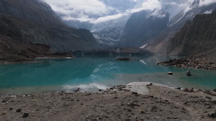 Mountain lake reflection. a view of a clear lake under the foot of a snowy mountain surrounded by mountains. Beautiful Mountain Lake in Nepal. A snowy mountain with Glacial Lake