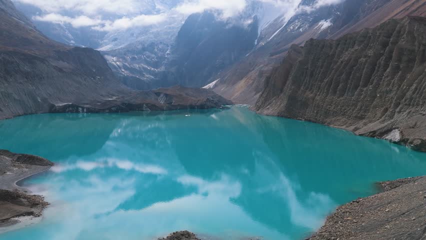 Mountain lake reflection. a view of a clear lake under the foot of a snowy mountain surrounded by mountains. Beautiful Mountain Lake in Nepal. A snowy mountain with Glacial Lake